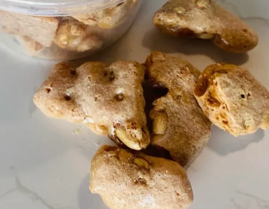 Freeze-dried peanut brittle pieces with airy, crunchy texture and golden color in a resealable bag